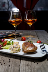Mynh steak with salad and mushroom appetizer on a white plate on a background with wine