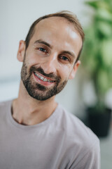 Obraz premium Portrait of a smiling man wearing braces on teeth, with a casual hairstyle and serene expression, captured indoors with soft lighting and a calm surrounding atmosphere.