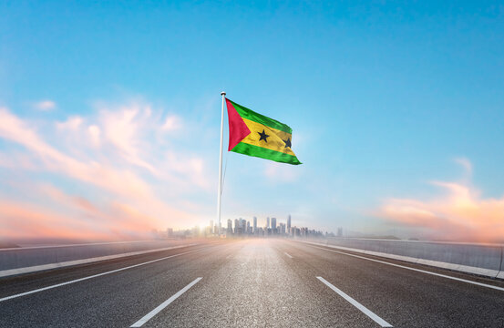 Sao Tome and Principe national flag with mast waving with beautiful skyline. A view from highway. Sao Tome and Principe flag for Republic Day and Independence Day. - Powered by Adobe