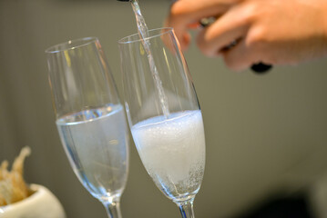 The bartender pours champagne into glasses