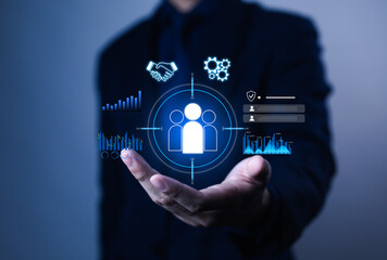 Businessman holding digital customer management icon with data analytics, teamwork, and innovation concept, representing CRM technology, business strategy, and customer engagement solutions.