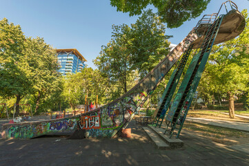 Obraz premium Stara zjeżdżalnia w parku w Bukareszcie – betonowa konstrukcja z graffiti