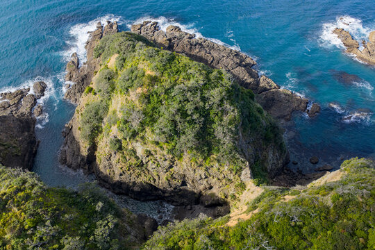 Aerial view of the rugged coastline where the turquoise sea meets the rocky shores, creating a stunning contrast of nature's beauty, Matapouri, Te Tai-tokerau, New Zealand.
