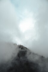 Misty mountain peak under a soft blue sky