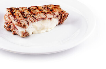 Grilled pork breast stuffed with cream cheese resting on white plate