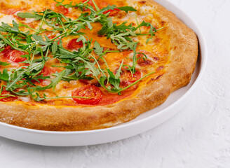Fresh italian pizza with arugula and tomato