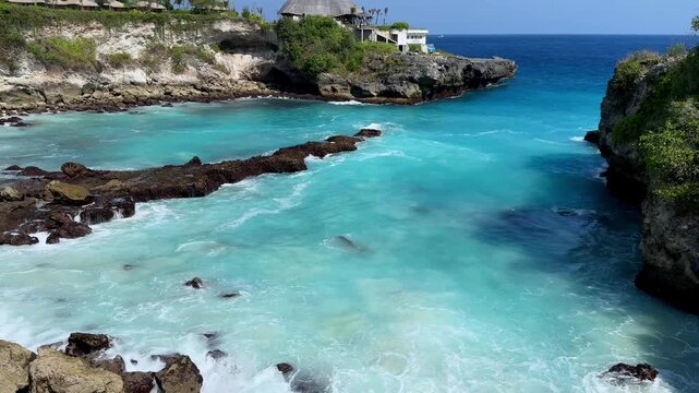 Bright blue tropical cove surrounded by rugged cliffs