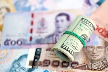 Thai baht currency money bills and bunch of us dollars. The concept of currency exchange