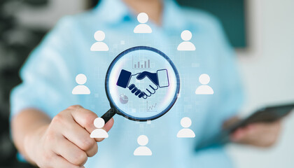 Businesswoman holding magnifying glass with handshake icon, business partnership, client...