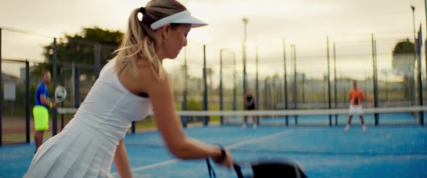 Padel players competing in an intense match on a vibrant blue outdoor court