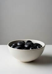 Serene black river stones displayed in a simple ceramic bowl