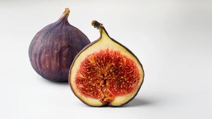 Fresh figs, whole and cut on a light background. Concept of healthy eating, natural products and vegetarian food. Horizontal.
