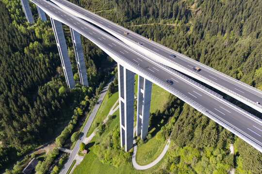 Aerial view of a towering viaduct soaring above the lush, green forests of Lavanttal, a testament to engineering amidst nature's embrace, Wolfsberg, Carinthia, Austria.