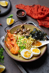 ramen noodle soup with prawn, mushrooms and egg in a bowl, vertical photo