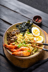 ramen noodle soup with prawn, mushrooms and egg in a bowl, vertical photo, copy space for text