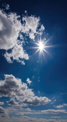 A vertical shot of a bright sunburst in a vibrant blue sky interspersed with puffy white clouds, creating a sense of airy openness