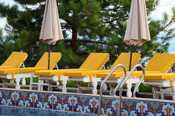 Yellow loungers by the pool at a resort on Bukhtarma Reservoir. Calm early autumn holiday vibe