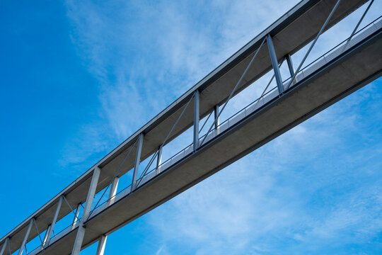 Fototapeta Pedestrian bridge with steel and glass lines against sky, minimal architectural abstraction symbolizing geometry, design, modern background and urban identity