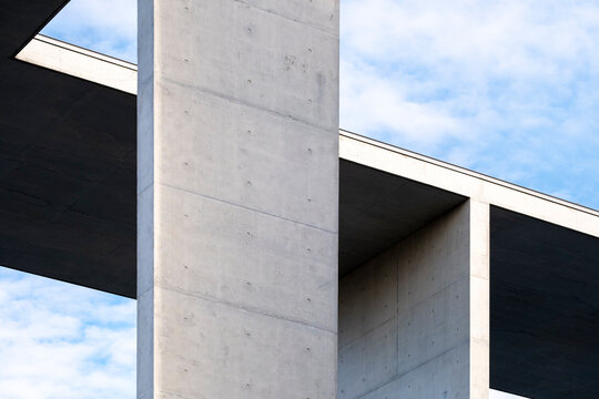 Minimal concrete facade with geometric openings and blue sky, abstract architectural composition symbolizing clarity, design, modern structure and contemporary urban order