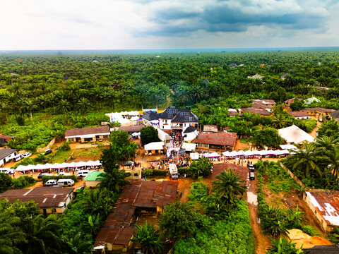 Aerial view of clustered buildings nestled amidst verdant trees under a moody sky, Amaolu Community, Orlu, Imo, Nigeria.