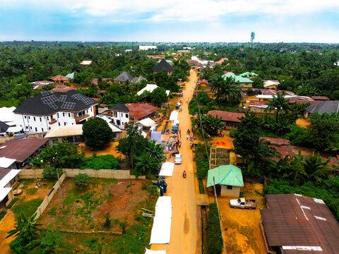 Aerial view of rooftops contrasting with lush greenery under a vast sky, Amaolu Community, Orlu, Imo, Nigeria.