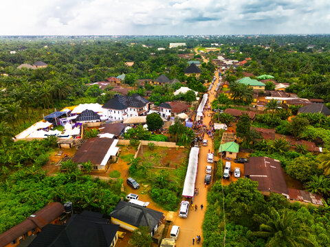 Aerial view of the vibrant Amaolu community, a tapestry of green foliage interspersed with buildings and a bustling main road, Orlu, Imo, Nigeria.