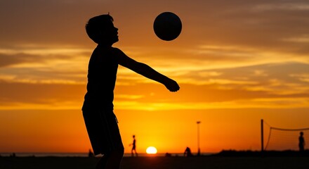 Silhouette of a child playing volleyball against a sunset sky