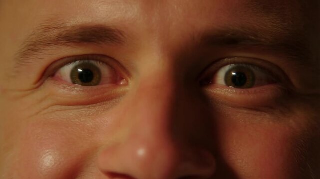 Caucasian male widening eyes, creating humorous facial expressions during close up portrait shoot