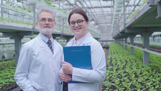 Portrait of two smiling agricultural specialists, horticultural business, cultivation