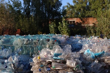 Mountains of compressed plastic bottles prepared for recycling — a symbol of the modern environmental problem and, at the same time, a solution through waste recycling