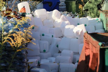 Pile of white plastic canisters at a waste collection site — symbol of plastic pollution and the urgent need for recycling