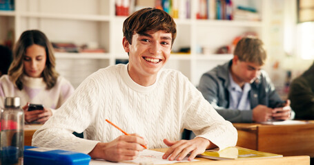 Fototapeta na wymiar High school student, portrait and writing in classroom for exam assessment, quiz and education. Teenager, boy and happy with aptitude test in lesson for scholarship, learning and curriculum knowledge