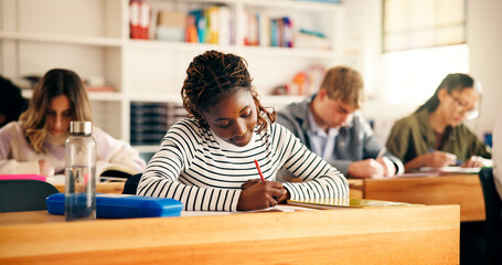 High school students, girl and writing in lesson for assessment quiz, evaluation test or learning. Teenager, education and people with exam essay in classroom for scholarship or curriculum knowledge © peopleimages.com
