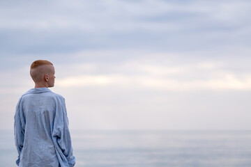 A teenager admires the seascape while looking into the distance. peaceful tropical summer holiday, travel, relaxation, summer vacation,