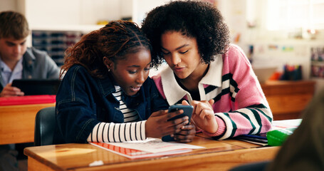 Education, internet and girls in classroom, smartphone and conversation with social media. Students, teenagers or friends with discussion, high school or cellphone with knowledge, app or test results