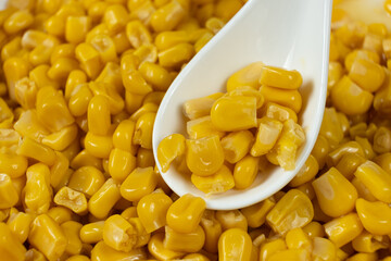Sweet canned corn in a spoon close-up