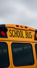 Close-up of yellow school bus roof with &ldquo;SCHOOL BUS&rdquo; lettering and lights