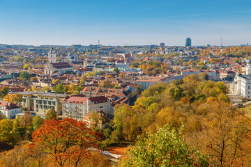 Fototapeta premium Stunning autumn view of Vilnius showcasing colorful trees and historic architecture across the city skyline