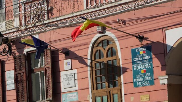 European and Romanian flag waving in the facade of a building. Slow motion