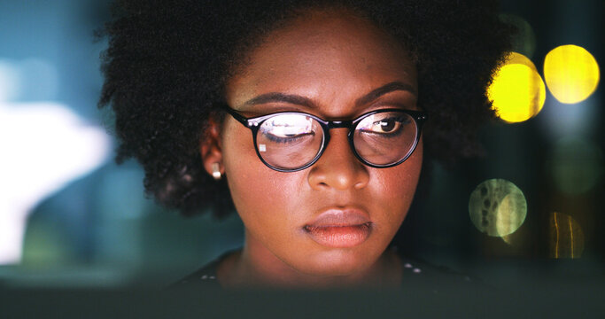 Business, woman and computer in office at night for economy news, trading deadline or bokeh. Serious trader, black person or PC reflection for NFT account review, investment report or market analysis