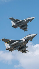 Two Eurofighter Typhoon jets flying in formation against blue sky