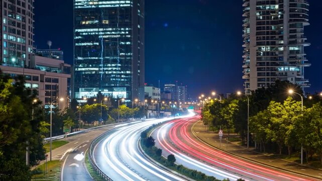 Circulation urbaine nocturne avec tra&icirc;n&eacute;es de lumi&egrave;res.