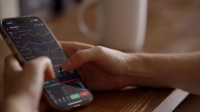 Person checking cryptocurrency price charts on mobile phone . Crypto trading 