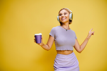 Young beautiful blonde woman in trendy outfit enjoying music in a vibrant studio setting
