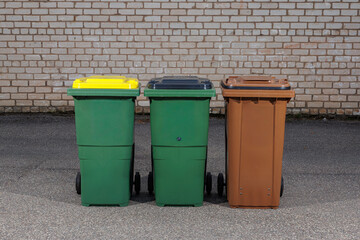 Three Color Coded Recycling and Waste Bins Outdoors