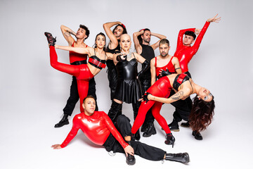 Queer dancers striking a pose in red and black outfits