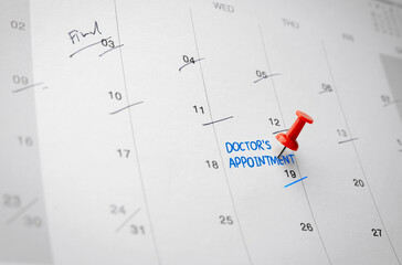 Red pin on calendar page with Doctor's appointment reminder. Health care concept, and annual health...