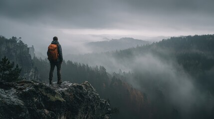 Adventurer gazing at misty mountain landscape