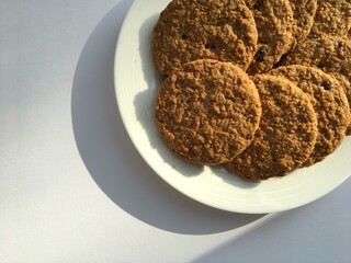 Close up of delicious cookies on white plate on white background