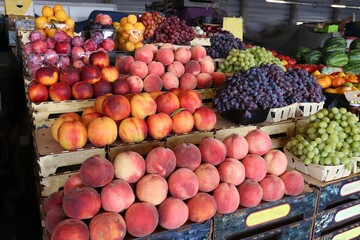 Colorful fresh fruits at the market — peaches, grapes, plums, and other seasonal gifts of nature in wooden crates